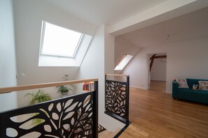 Ein modernes Interieur mit Holzboden, einem blauen Sofa und einem schwarzen Zierteil.