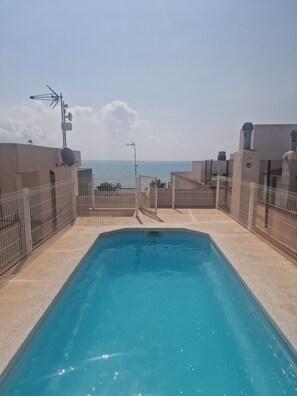 A rooftop swimming pool with a view of the sea, surrounded by buildings and equipped with satellite dishes. - Mediterranean Vacation Rental (Valencia) – Just 100 m from the Beach (Platja de Nules)