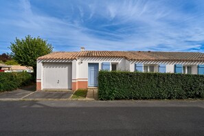 A single-story building with a tiled roof, a white facade, and a blue door. - Le Green de Pornic - A 2km du Port (Pornic)
