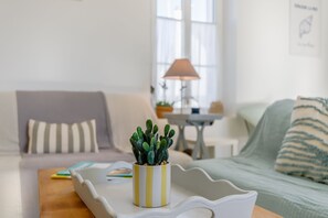 Ein Wohnzimmer mit einer Couch, einem Couchtisch mit einem Kaktus und einer Lampe.