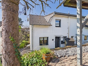 Een twee verdiepingen tellend huis met een pannendak, een schotelantenne en een klein raam.
