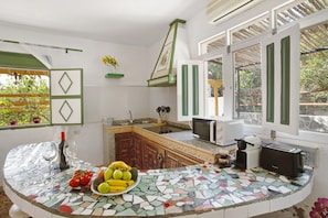 A kitchen with a tiled countertop, a sink, a microwave, a toaster, and a window with a view of greenery. - Entire Country Estate 'Fani' with 4 Houses plus 1 Studio, Sea Views, Wi-Fi and Air Conditioning (Los Corralillos)