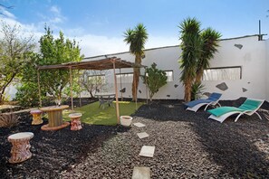 A patio with a pergola, outdoor seating, and a small garden area. - Entire Country Estate 'Fani' with 4 Houses plus 1 Studio, Sea Views, Wi-Fi and Air Conditioning (Los Corralillos)
