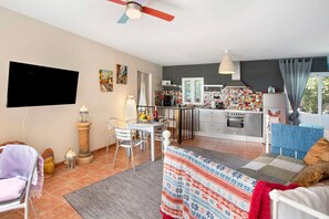 A modern living room with a TV, dining area, kitchen, and a balcony with a view. - Entire Country Estate 'Fani' with 4 Houses plus 1 Studio, Sea Views, Wi-Fi and Air Conditioning (Los Corralillos)