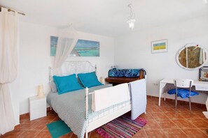 Une chambre à coucher comprenant un lit, une table de chevet, une chaise, un bureau et un miroir.