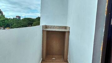 A narrow balcony with a tiled floor, white walls, and a small ledge.