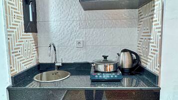 A compact kitchen with a sink, stove, and a small refrigerator.