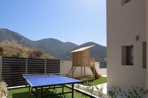 A ping pong table in a backyard with a wooden playhouse and a mountain view. - Dias Grand Villa - Indoor & Outdoor Pools (Bali)
