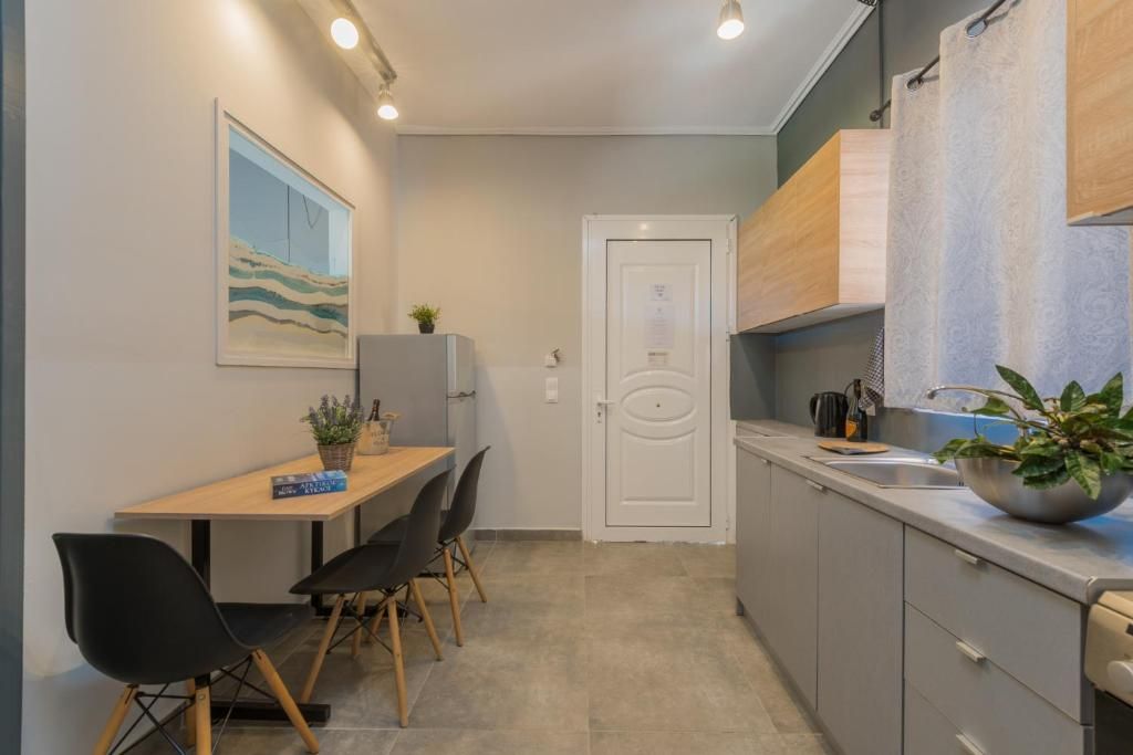 Una cocina compacta con comedor, una puerta blanca y un cuadro en la pared.