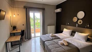 A hotel room with a bed, a desk, and a ceiling fan.