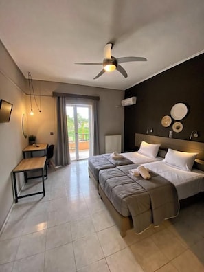 A hotel room with a bed, a desk, and a ceiling fan. - Filoxenia Luxury Studios & Apartments (Zakynthos)