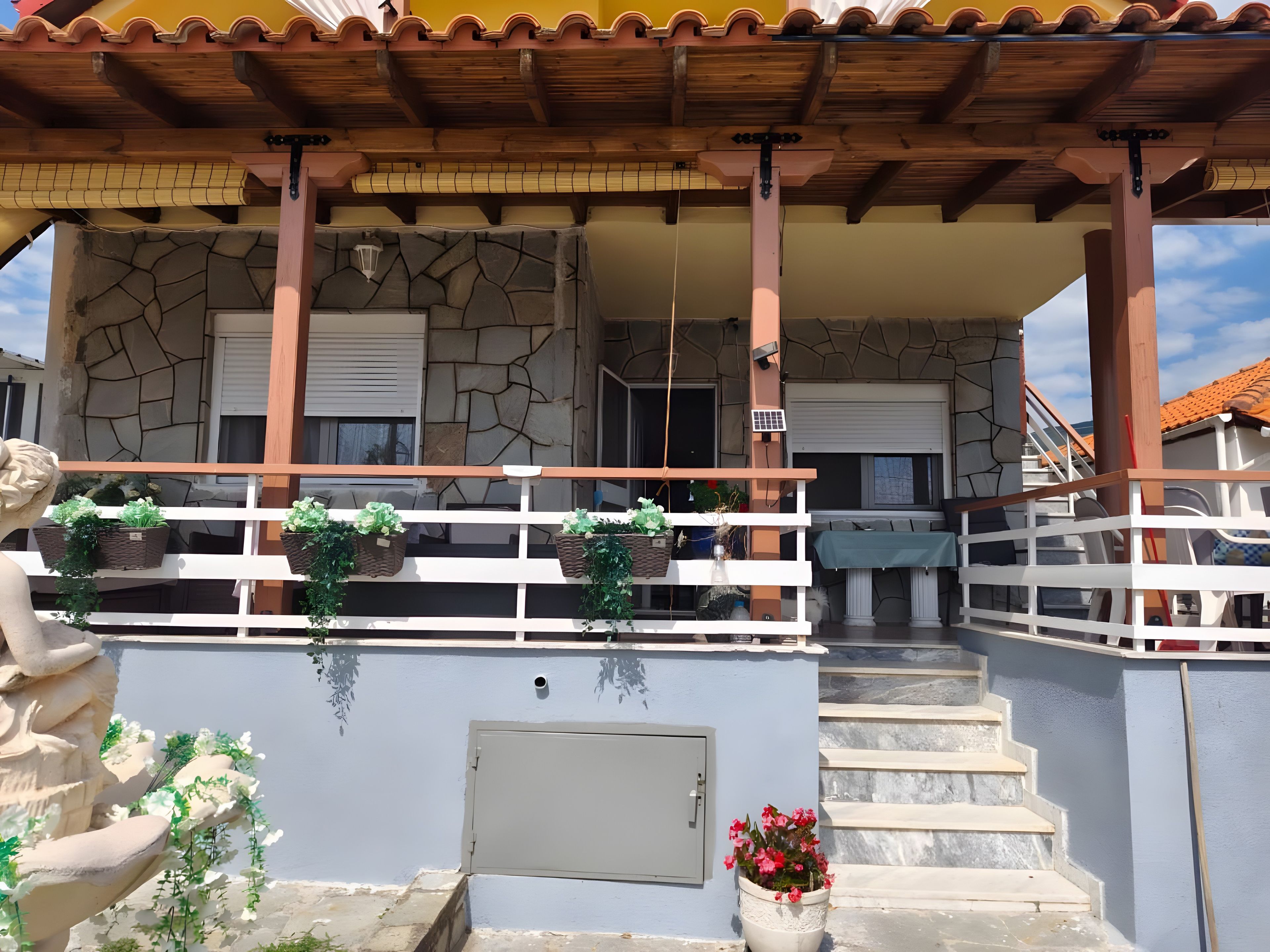 Un bâtiment doté d’une façade en pierre, d’un balcon en bois et d’un escalier menant à l’entrée.