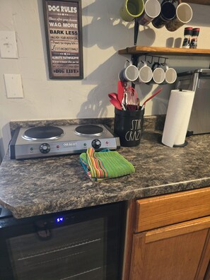 A kitchen counter with a stove, a colorful towel, and a sign with motivational phrases. - Dancin' Dogs, The Dog House, is a one bedroom bungalow in Newberry FL (Newberry)