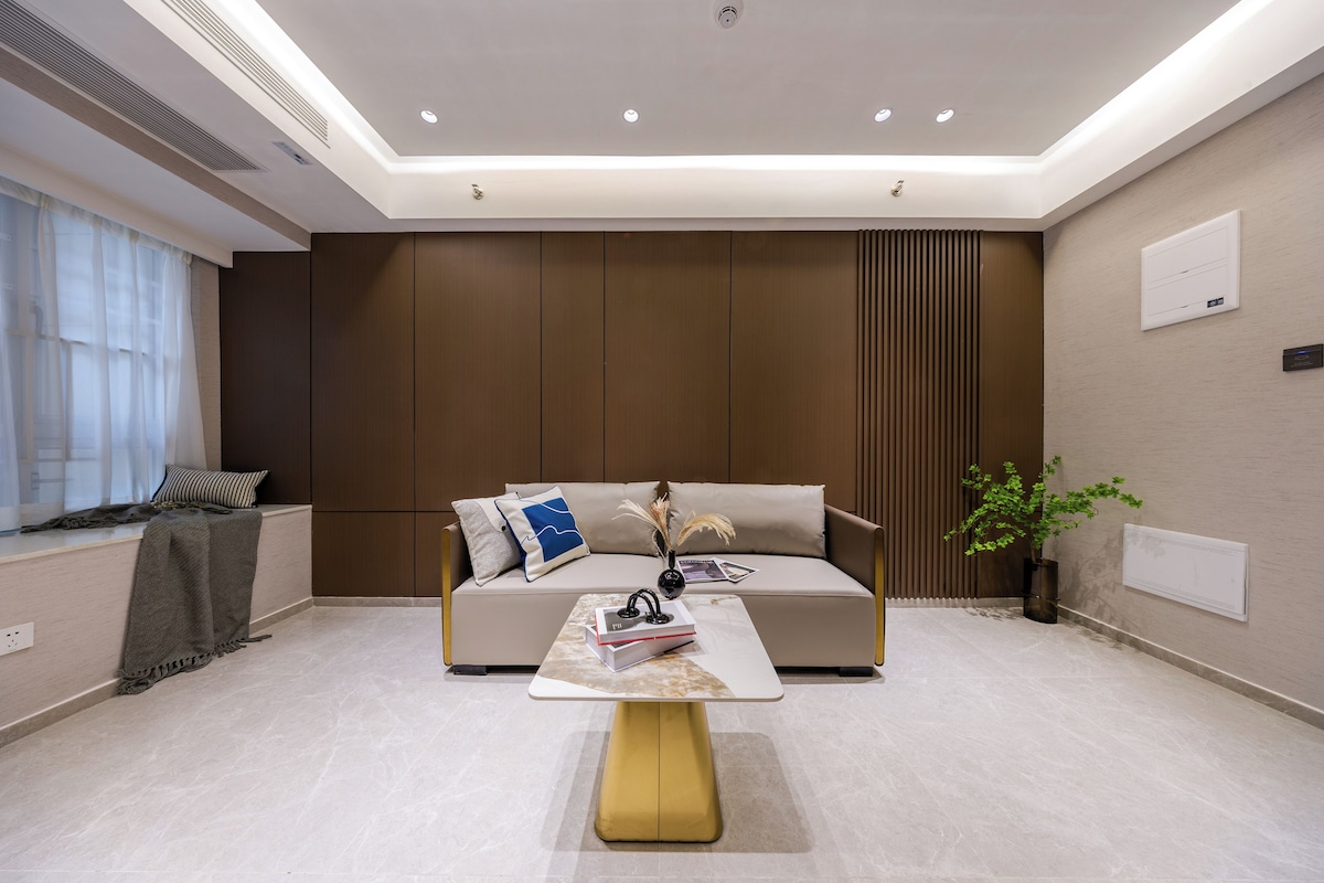 A modern living room with a sofa, a coffee table, and a plant.