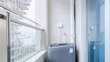 Un baño pequeño con ventana, un perchero y un calentador de agua.