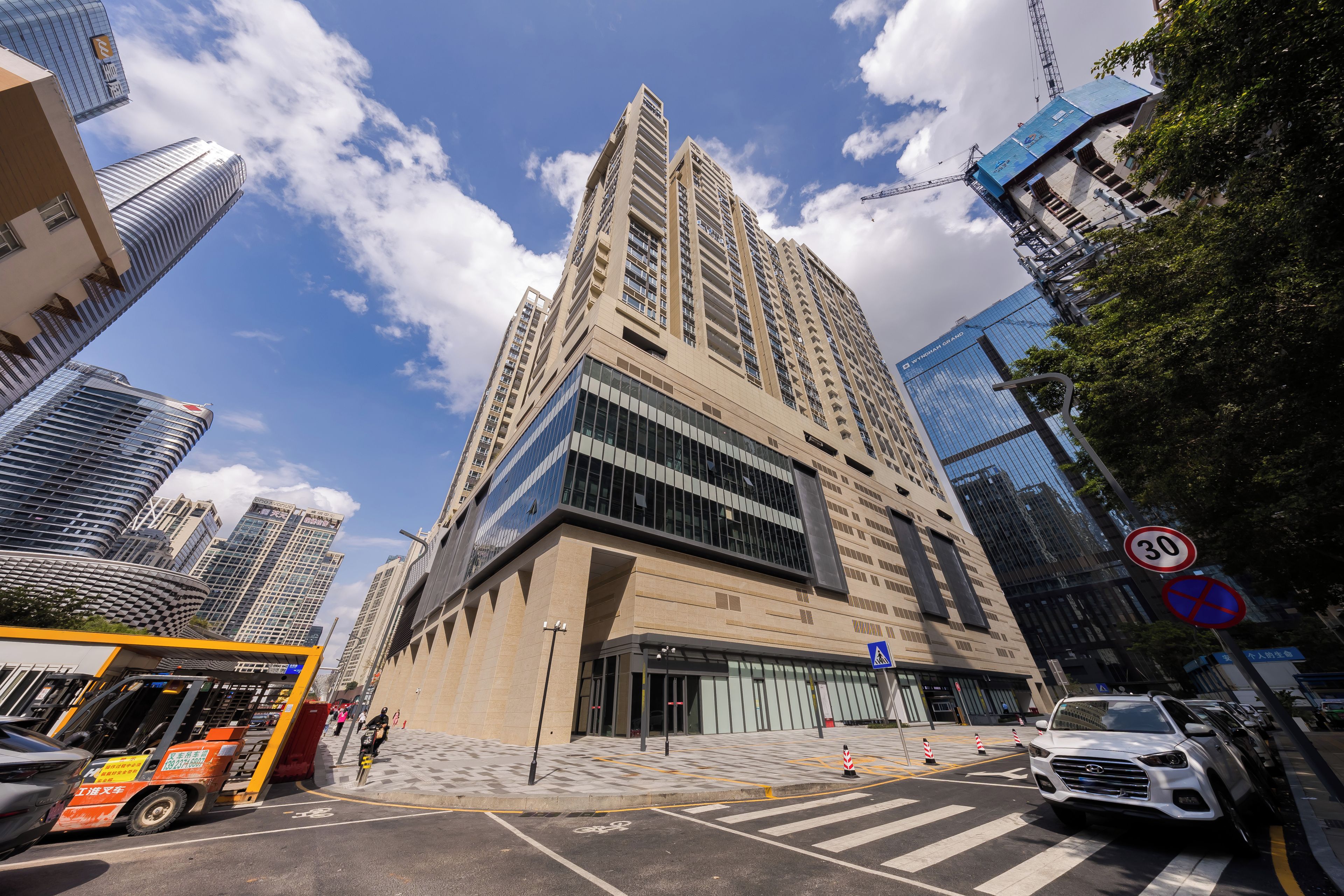 Un edificio de gran altura con un diseño arquitectónico moderno, que destaca por su entrada principal y fachada de vidrio.