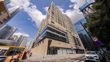 Un edificio de gran altura con un diseño arquitectónico moderno, que destaca por su entrada principal y fachada de vidrio.