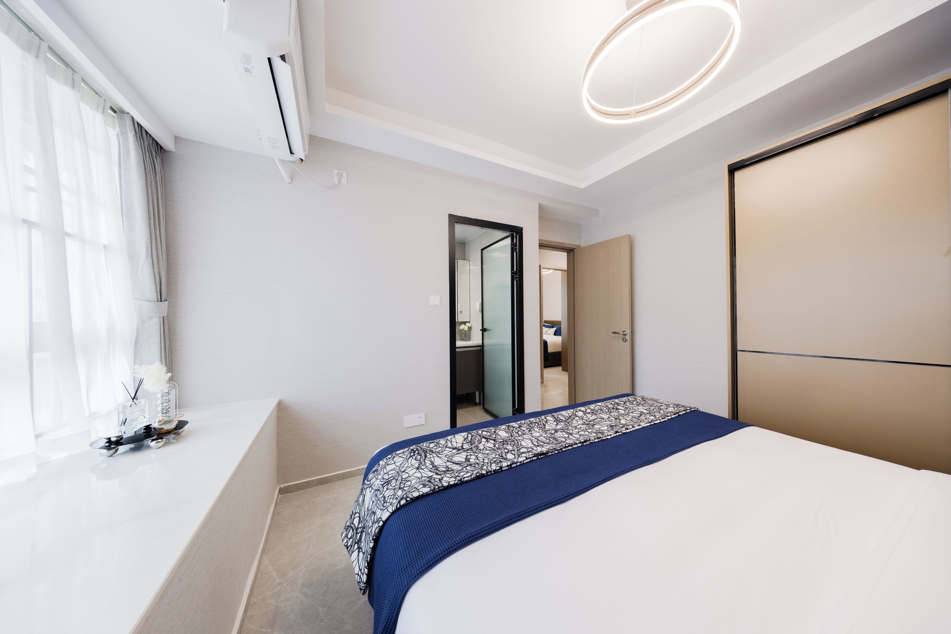 Un dormitorio moderno con una cama grande, una mesita de noche, un espejo y un armario.