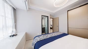 Un dormitorio moderno con una cama grande, una mesita de noche, un espejo y un armario.