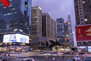 A cityscape with high-rise buildings, a busy intersection, and a large billboard. - Gepai Cityview Hotel Futian Expo (Shenzhen)