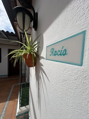 A potted plant next to a wall with a sign reading 'Rocía'. - Country House 'Casa Aires Del Rocío' (El Rocío)