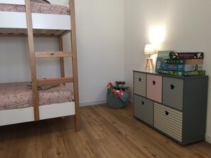 A bunk bed with a wooden ladder, a dresser with multiple drawers, and a small lamp. - Holiday Home 'Family Home à 400 m de la plage Mauret' with Garden and Wi-Fi (Andernos-les-Bains)