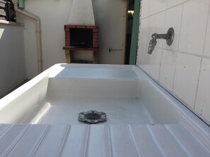 A bathroom with a white bathtub, a shower area, and a tiled wall. - Holiday Home 'Family Home à 400 m de la plage Mauret' with Garden and Wi-Fi (Andernos-les-Bains)