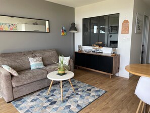A modern living room with a grey sofa, a round coffee table, and a patterned rug. - Apartment 'Goulvars' with Sea View - Quiberon (Quiberon)