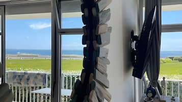 Een kamer met uitzicht op zee, een groot raam en een unieke wanddecoratie.