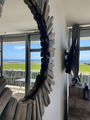 A room with a view of the sea, a large window, and a unique wall art installation. - Apartment 'Goulvars' with Sea View - Quiberon (Quiberon)