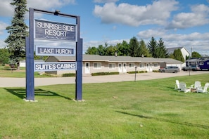 A sign for Sunrise Side Resort with a building labeled 'Suites Cabins' in the background. - Beach Access! Sunrise Side Resort Retreat (Greenbush)