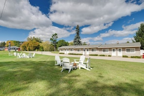 A motel with a grassy lawn, outdoor seating area, and a clear sky. - Beach Access! Sunrise Side Resort Retreat (Greenbush)