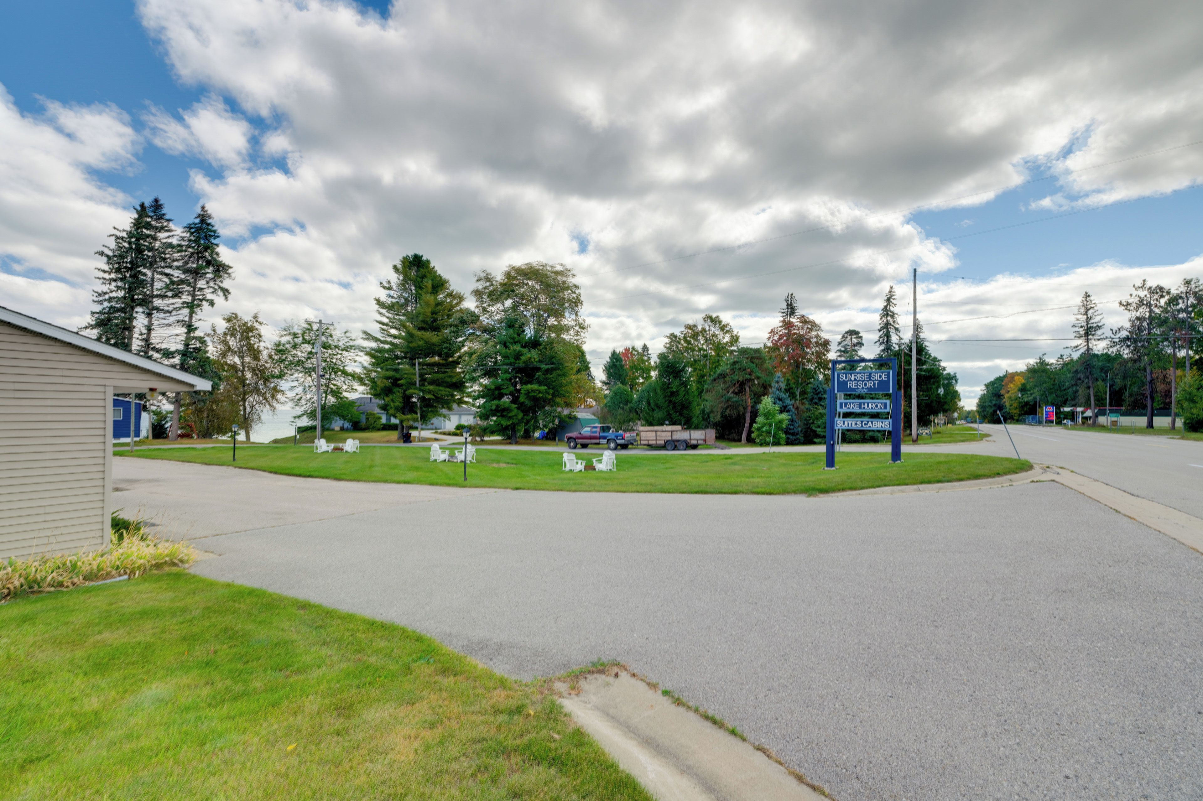 Una carretera que lleva a un resort, con un cartel que indica 'Sunrise Side Lake Huron Suites Cabins'.