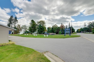 A road leading to a resort with a sign indicating 'Sunrise Side Lake Huron Suites Cabins'.