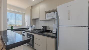 A modern kitchen with a built-in washer, a microwave, and a refrigerator.