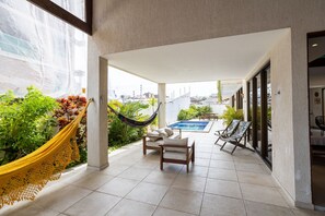 A spacious outdoor area with a pool, seating, and a hammock.