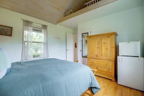 A bedroom with a bed, wooden cabinet, and a white refrigerator. - Game Room, Private Dock! Grand Lake Group Retreat (Grove)