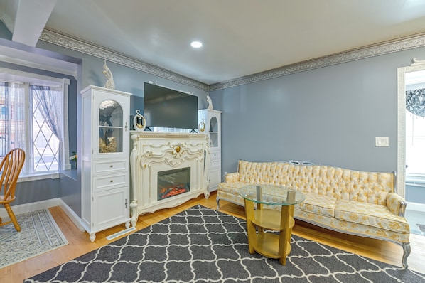 A living room with a fireplace, a sofa, and a glass coffee table.