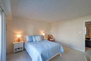 A bedroom with a bed, nightstands, a chair, and a lamp. - Walk to Beach! Updated Brigantine Retreat (Brigantine)
