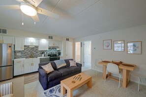 A modern living room with a sofa, coffee table, and a dining area with a table and chairs. - Walk to Beach! Updated Brigantine Retreat (Brigantine)