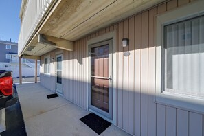 A residential building with a front door, a garage door, and a vehicle parked outside. - Walk to Beach! Updated Brigantine Retreat (Brigantine)