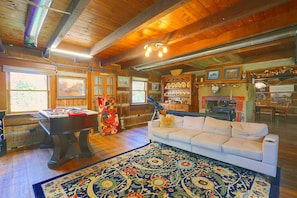 A cozy room with a pool table, a sofa, and a large rug. - Hot Tub & River Views! Elizabeth Cabin on 10 Acres (Elizabeth)