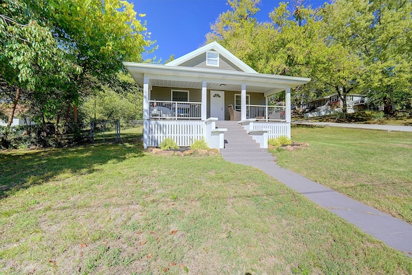 A single-story house with a front porch, a visible door, and a small front yard.