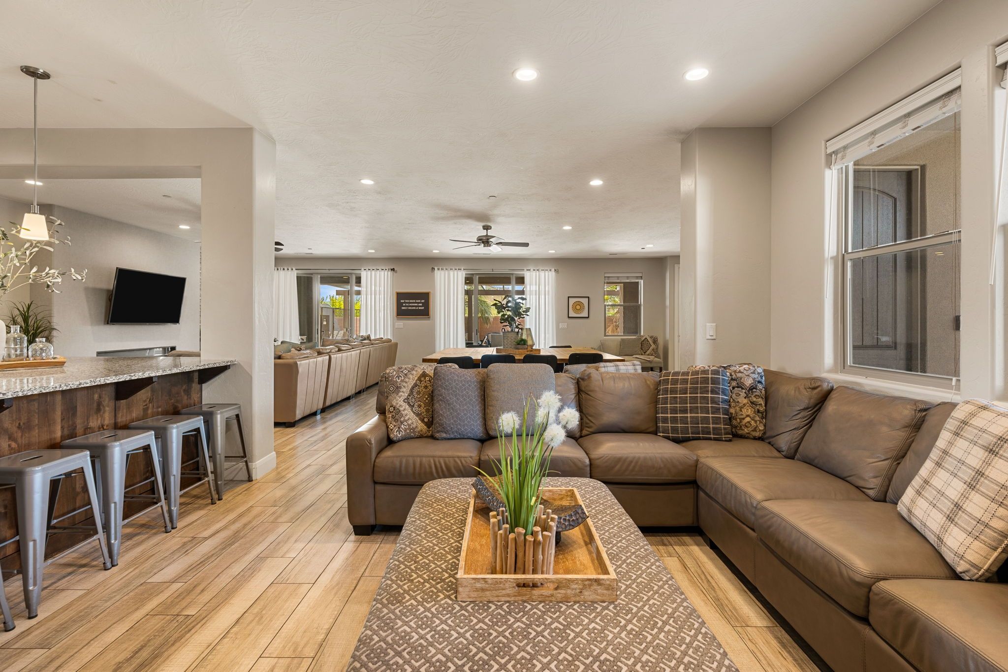 A spacious living area with a large sofa, a coffee table, and a dining table.