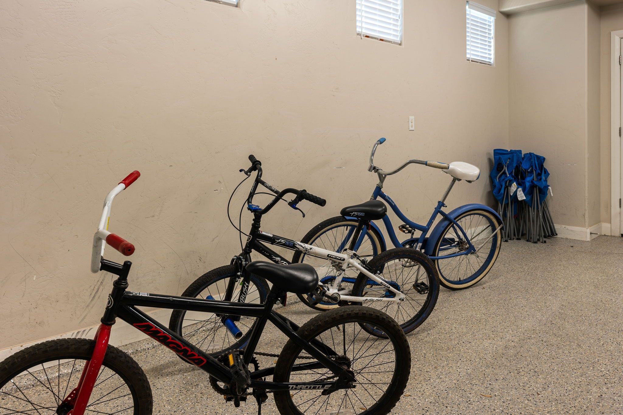 A room with beige walls, two bicycles, and a door.