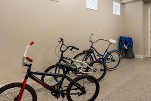 A room with beige walls, two bicycles, and a door. - Grand Resort #98 9 Bedroom Home (Ivins)
