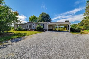A single-story house with a covered porch and a gravel driveway.