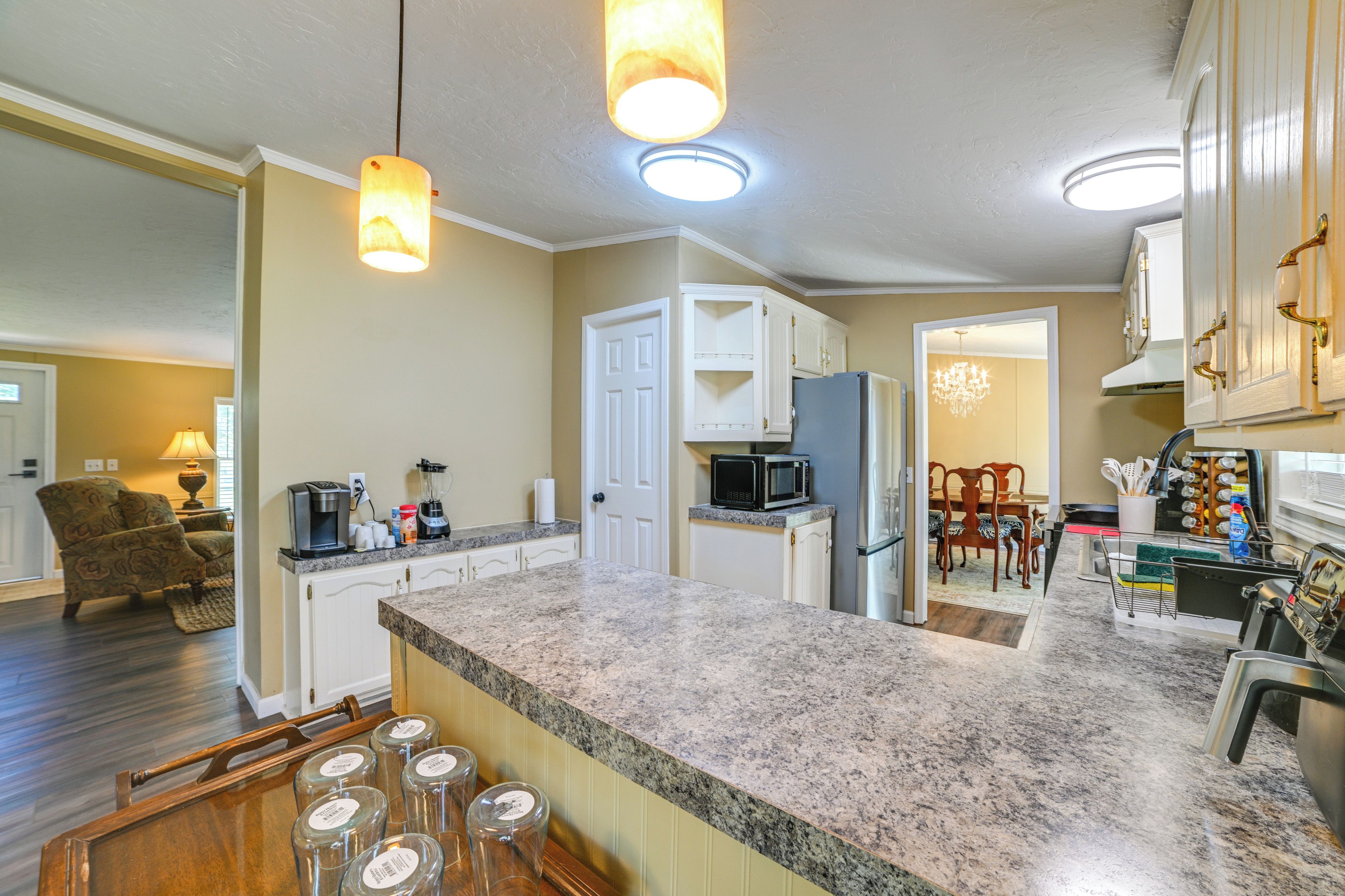 A kitchen with granite countertops, white cabinets, and a built-in microwave.