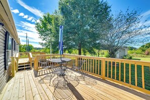Eine Holzterrasse mit Tisch und Stühlen, umgeben von einem Holzaumschlag.
