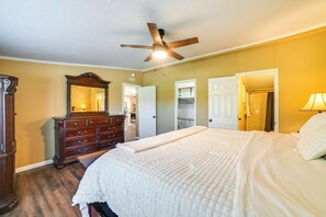 A bedroom with a bed, dresser, mirror, ceiling fan, and a walk-in closet. - 22-acre Farm Retreat < 8 Mi to Kentucky Lake! (Dexter)